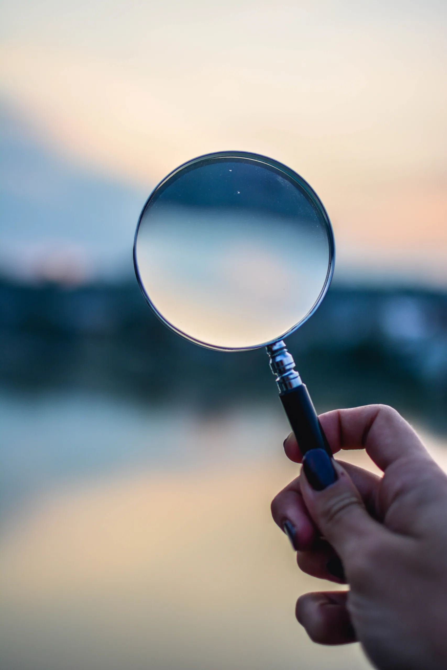 Hand holding a magnifying glass